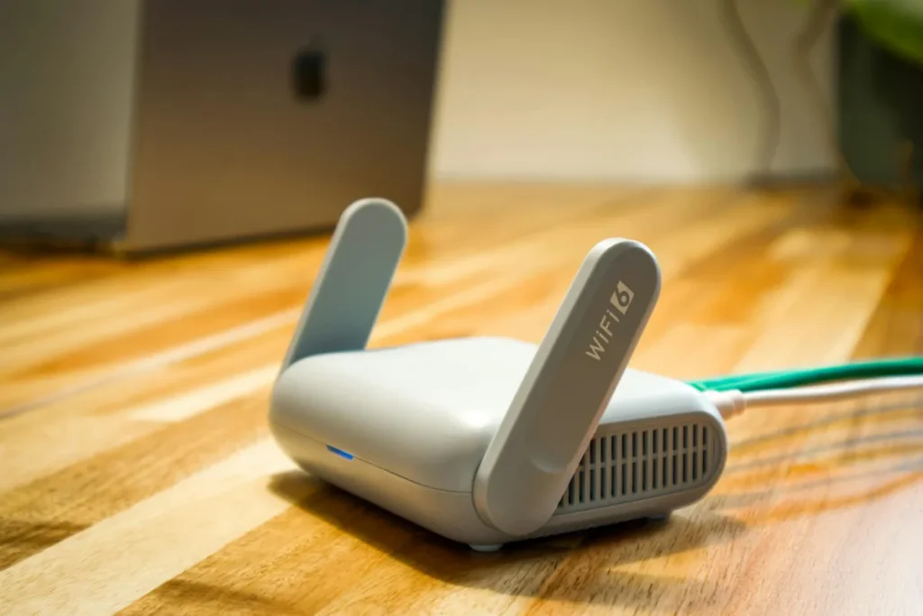 Router WiFi 6 dengan antena dan kabel di atas meja kayu untuk jaringan rumah modern